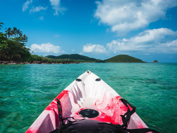 Kayak paddling to tropical island with emerald water and summer blue sky. koh mak island, thailand.