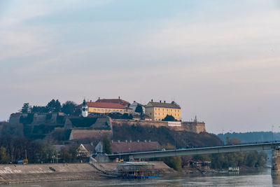 Bridge over river against buildings in city