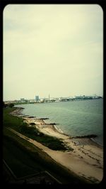 Scenic view of sea and city against sky