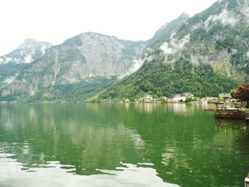 Scenic view of lake by mountains against sky