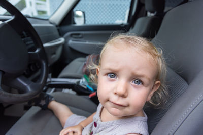 Portrait of cute girl sitting in car