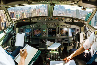 Pilots sitting in cockpit over city