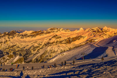 Scenic view of snowcapped mountains against clear blue sky