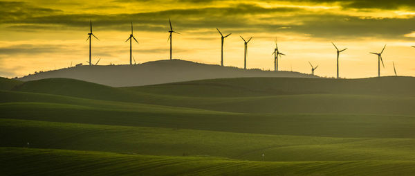 Windmill on field against sky