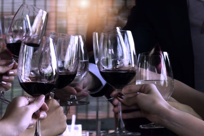 Midsection of people in glass on table at restaurant