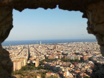 Aerial view of city by sea against clear sky