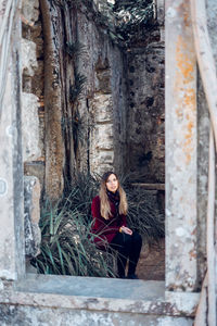 Portrait of beautiful woman seen through window in abandoned building