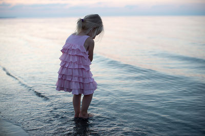 Playful girl at beach against sky