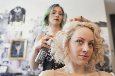 A hair dresser styling a customer's hair.
