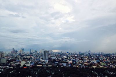 Cityscape against cloudy sky