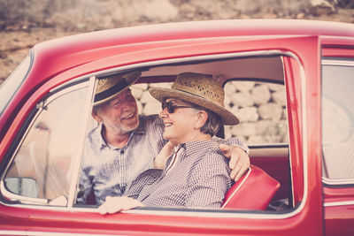 Cheerful senior couple traveling in car