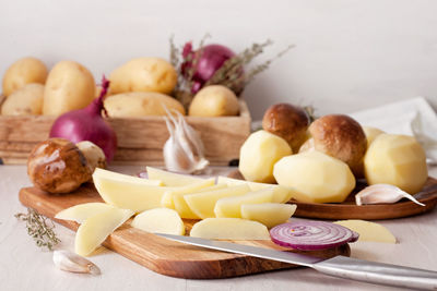 Potato and onion slices on cutting board