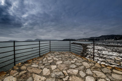 Fence by sea against sky