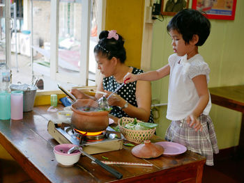 Boys standing on table in kitchen