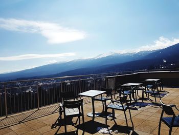 Chairs and tables at restaurant against sky