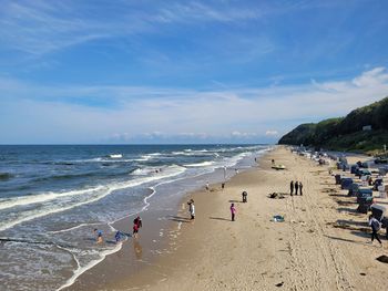 People on beach against sky