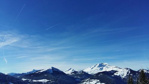 Scenic view of snowcapped mountains against blue sky