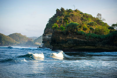 Rock formations by sea against sky