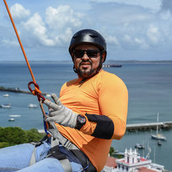 Man with helmet, glove and equipment practicing rappel on elevador lacerda