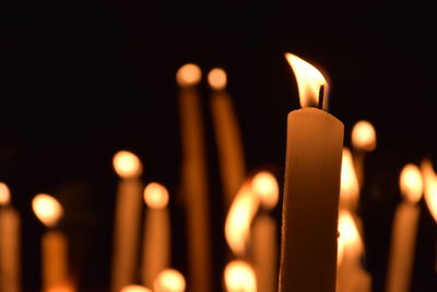 Close-up of lit candle in dark room