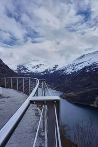 Footbridge against cloudy sky