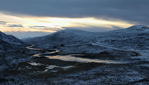 Scenic view of snowcapped mountains against sky during sunset