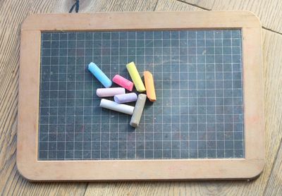 High angle view of colorful chalks on blackboard over table