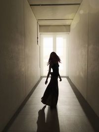 Full length of woman dancing in corridor