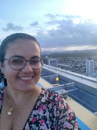 Portrait of smiling woman against sky