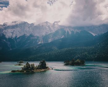 Scenic view of sea and mountains against sky