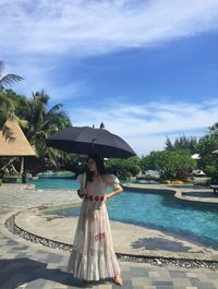 Woman at swimming pool against sky