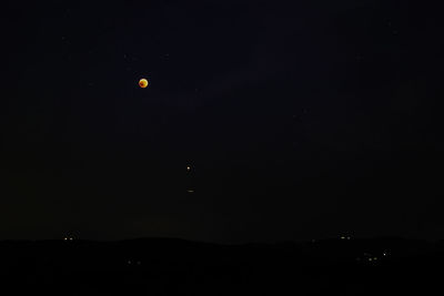 Low angle view of silhouette moon against sky at night