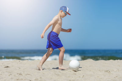 Man playing with ball on beach