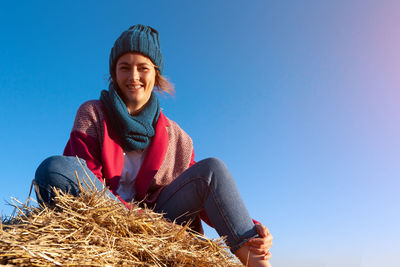 Beautiful modern urban young woman wearing blue knitting hat, pink coat and jeans. 