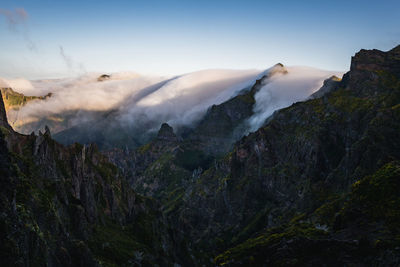 Mountain range covered in clouds on madeira island, portugal, at sunrise