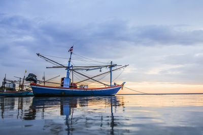 Sailboat moored on sea against sky