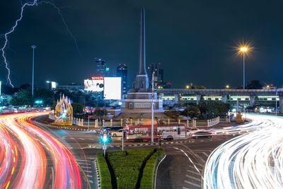 Light trails on road against sky at night