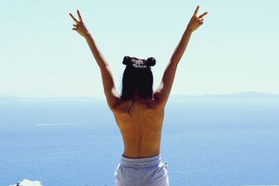 Rear view of woman standing against clear sky