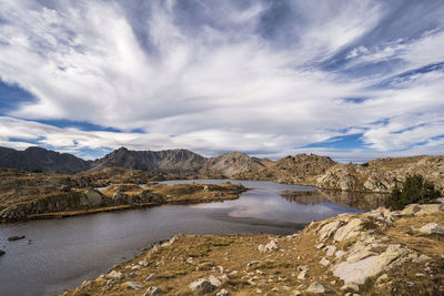 Scenic view of lake by mountains against sky