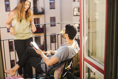 Happy couple with guidebook planning vacations at balcony