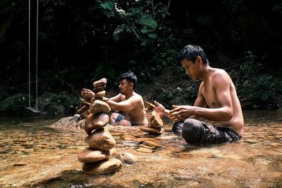 Young men sitting on shore