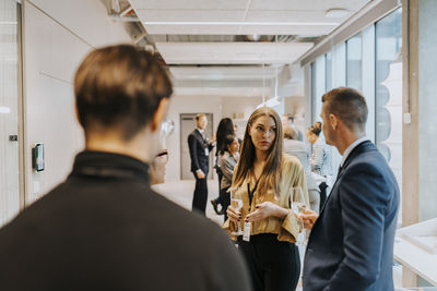 Business delegates with drink discussing strategy during networking event