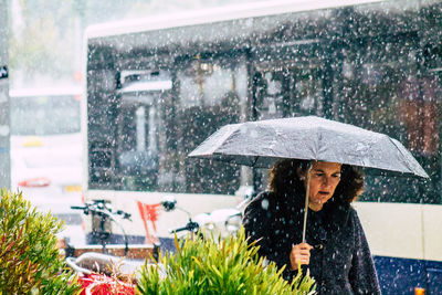 Woman holding wet umbrella during rainy season