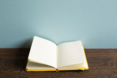 Close-up of open book on table against white background