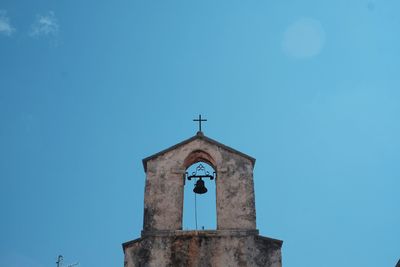 Low angle view of rustic church against clear blue sky
