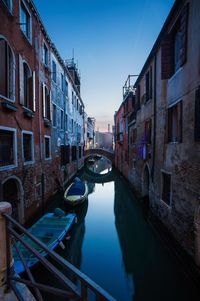 Boats in canal along buildings