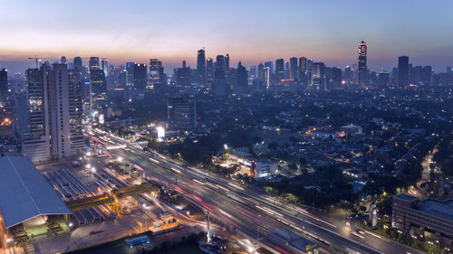 High angle view of illuminated street amidst buildings in city