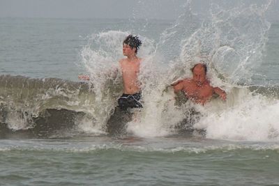 Father with son swimming in sea
