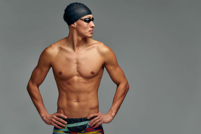 Shirtless man standing against white background