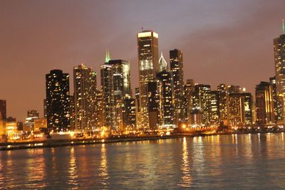 Illuminated cityscape against sky at night